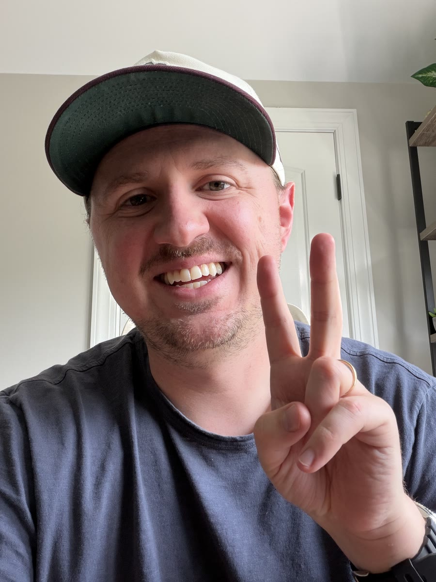 Alex Reeder smiling and holding up a peace sign